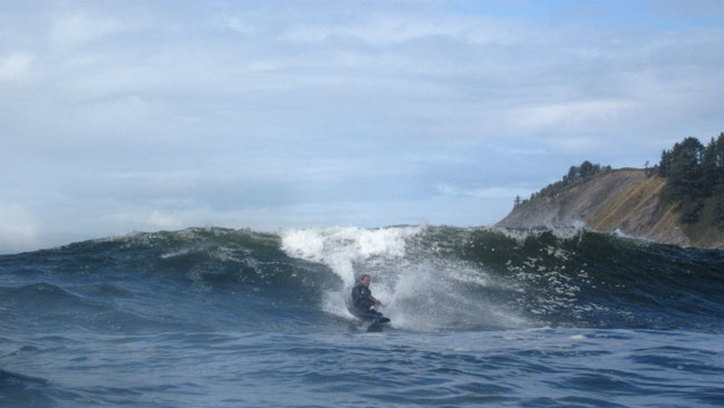 surfing a kayak on the oregon coast